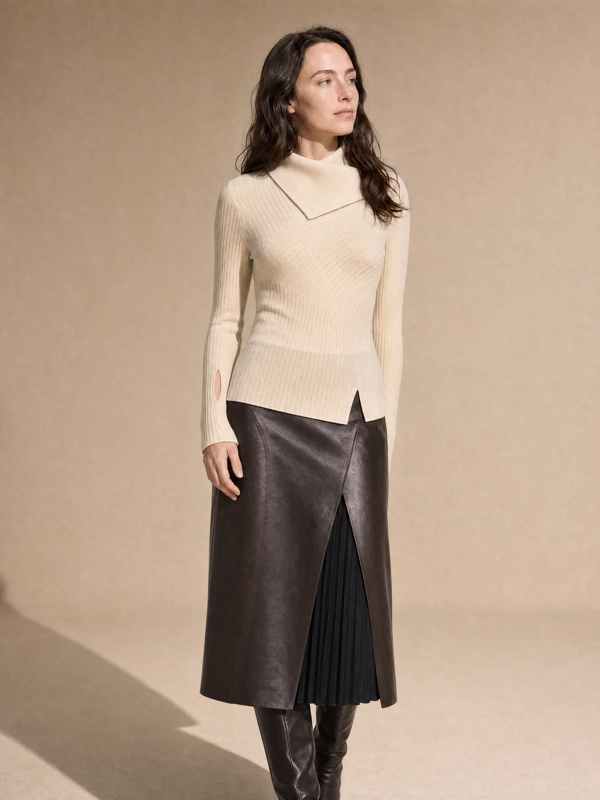 Full-body on-model image of a ribbed cream knit and leather skirt