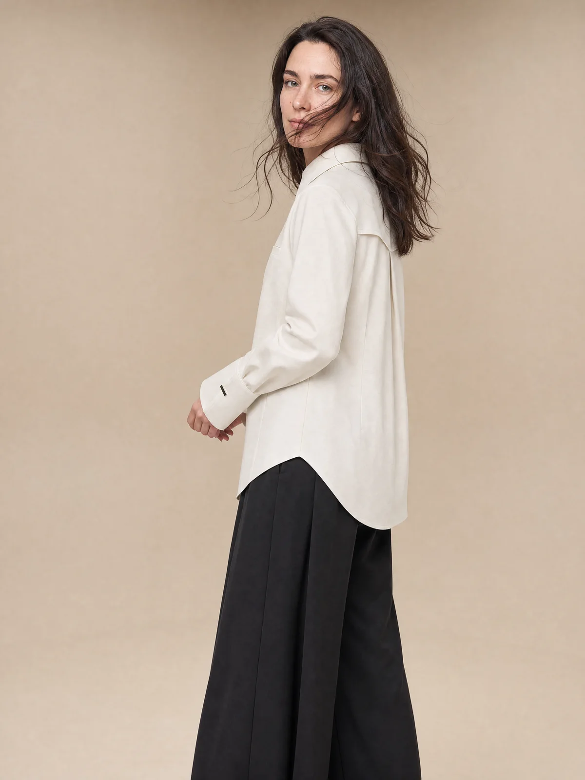 Full-body on-model studio image of a cream collared shirt in a relaxed stance