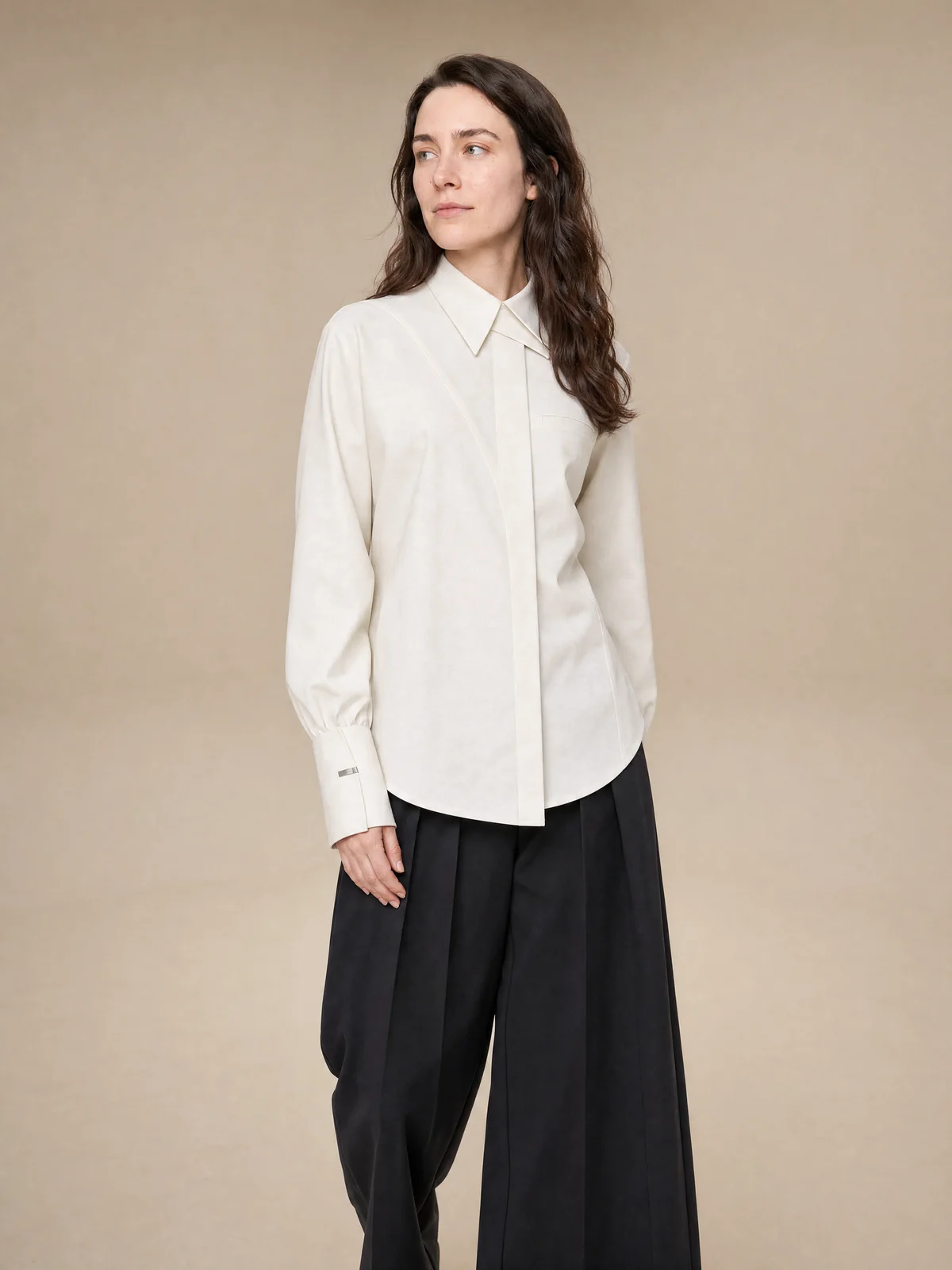 Profile on-model studio image of a cream collared shirt in motion